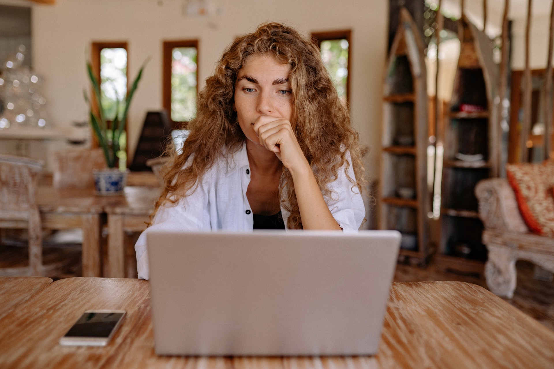 Woman thinking in front laptop